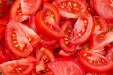 Slices of the fresh red tomatoes cut for salad preparation, top view close-up