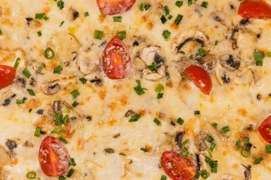 Etli, mantarlı, vişneli, domatesli baharatlı pizza, yakın çekimin üst görüntüsü.