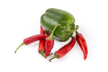Taze taze, olgun yeşil çan biberleri ve beyaz bir zemin üzerinde kırmızı kırmızı biber kabukları.