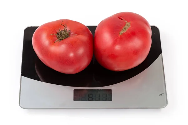 白い背景に家庭用デジタルキッチンスケール上の2つの全体の大きな熟したピンクのトマト — ストック写真