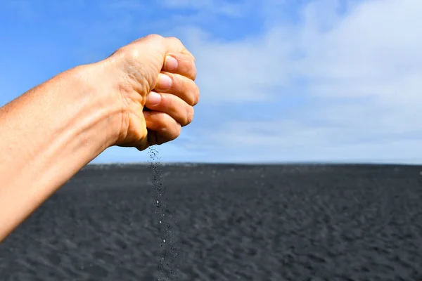 Closeup Closed Hand Dropping Grains Black Volcanic Sand Clearing Cloudy — Fotografia de Stock