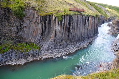 Very deep Canion with flowing river and with margins formed by natural vertical basalt columns