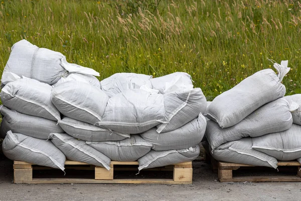 Beyaz kum torbalı sarı ahşap paletler bina için dışarıda.