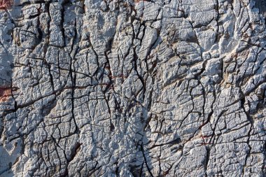 ABeautiful texture of natural gray and yellow granite stone surface with cracks in the photo