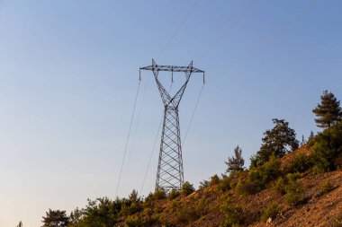 Mavi gökyüzü arka planında siyah bir elektrik hattı var. dağ manzarası