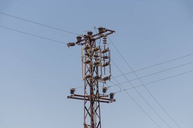 Mavi gökyüzü arka planında siyah bir elektrik hattı var.