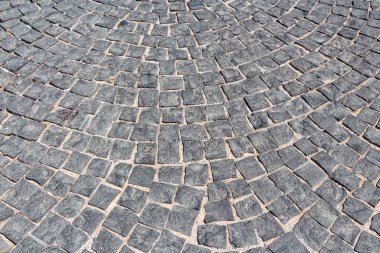 Parkta kumlu gri kare taşların güzel bir dokusu var.
