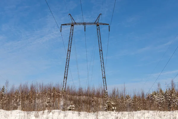 Czarna linia energetyczna jest na tle niebieskiego nieba. Krajobraz zimowy — Zdjęcie stockowe