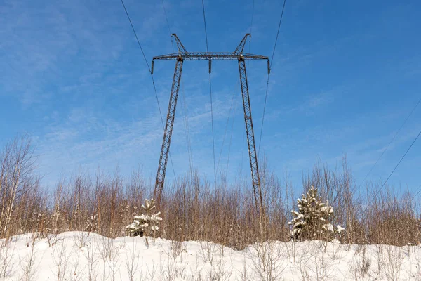 Czarna linia energetyczna jest na tle niebieskiego nieba. Krajobraz zimowy — Zdjęcie stockowe