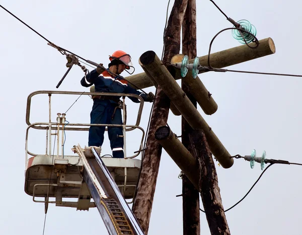 Elektryk łączy przewody na linii zasilania — Zdjęcie stockowe