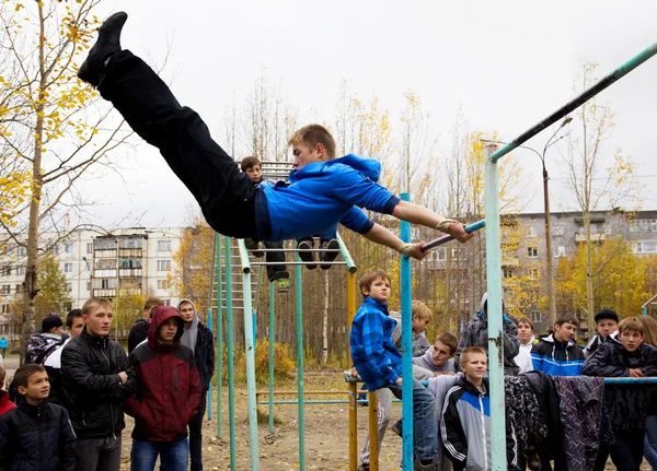 Young guys compete on the horizontal bar — Stock Photo, Image