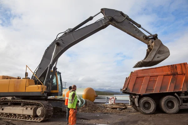 Grävskopan ösregnar på en dumper lyfte — Stockfoto