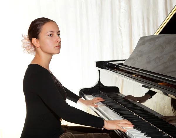 Una giovane ragazza che suona il pianoforte — Foto Stock