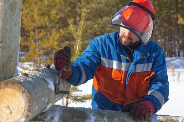 Werknemer in blauwe overalls mounts ondersteuning elektrische leidingen — Stockfoto