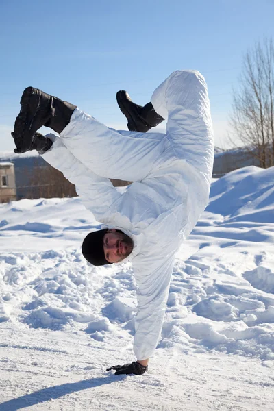 Soldier in white camouflage makes a break dance — Stock Photo, Image