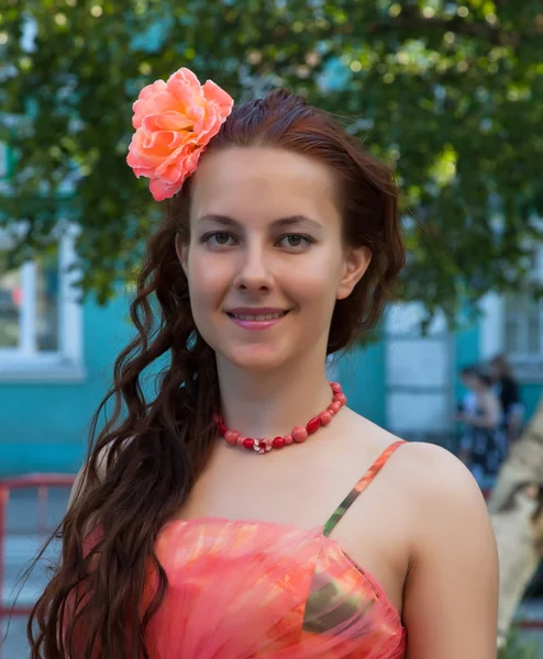 Portrait d'une fille en robe rose avec une fleur dans les cheveux — Photo