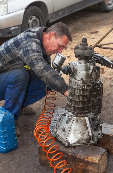 A man cleans the engine taken from the car for overhaul , withou — Stock Photo, Image