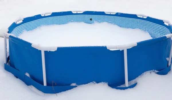 Piscina abandonada no inverno, rodeada de neve — Fotografia de Stock