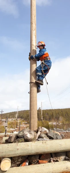 电工开始爬上电线杆 — 图库照片