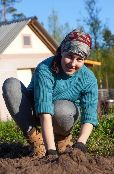 Ein junges Mädchen arbeitet im Garten der Hütte — Stockfoto