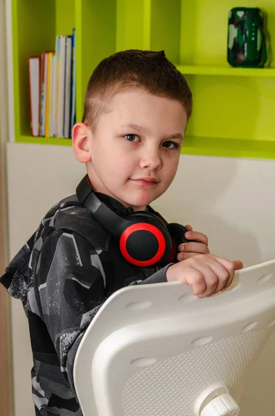Un niño escucha música en auriculares inalámbricos en casa. Fotos de stock