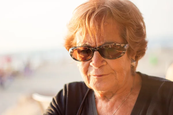 Thinking elderly woman outdoors — Stock Photo, Image