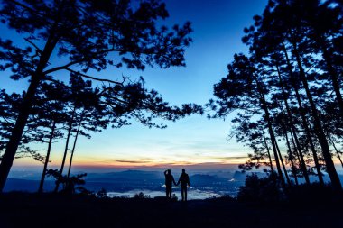 Güzel bir dağ sırtı ve gökyüzü olan siluet çift.
