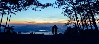 Güzel bir dağ sırtı ve gökyüzü olan siluet çift.