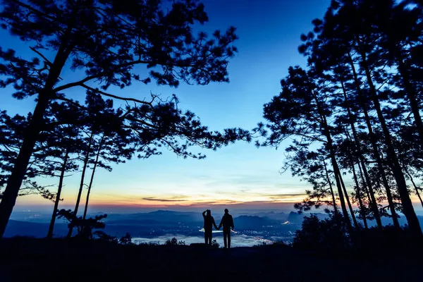Güzel bir dağ sırtı ve gökyüzü olan siluet çift.