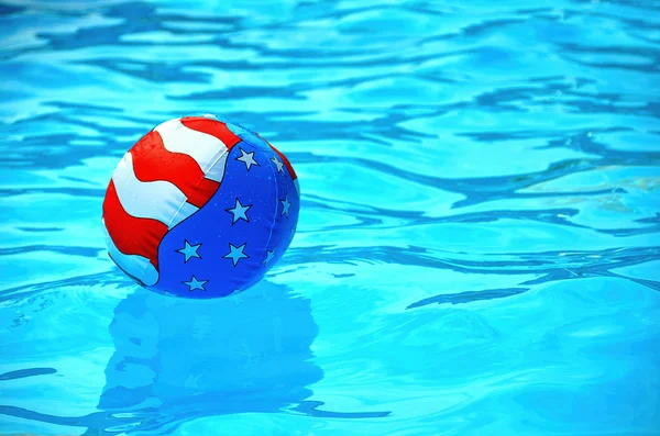 Patriotic beach ball in swimming pool — Stock Photo, Image