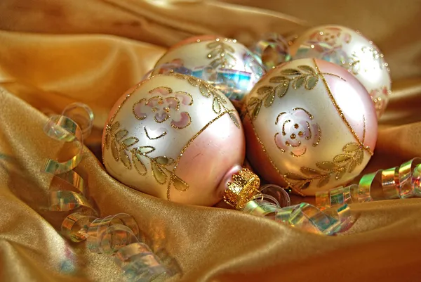 Gold Christmas ornaments on satin — Stock Photo, Image