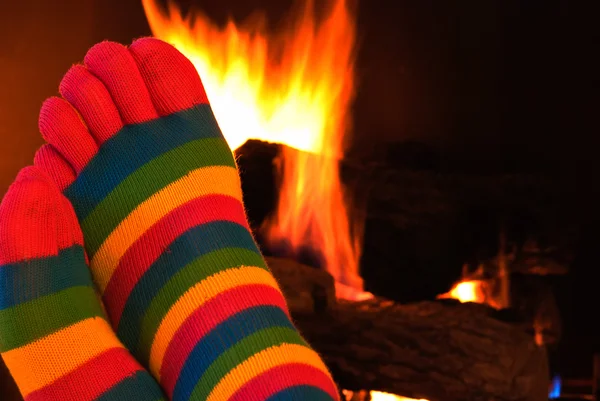 Striped toe socks by fireplace — Stock Photo, Image