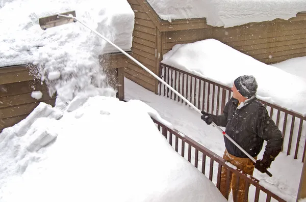 Hombre quitando nieve del techo —  Fotos de Stock