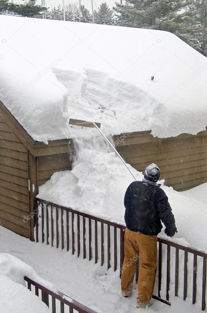 Man removing snow off roof