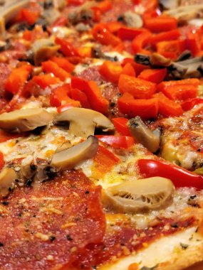 Biberli ve mantarlı pizzanın üstüne kırmızı dolmalık biber.