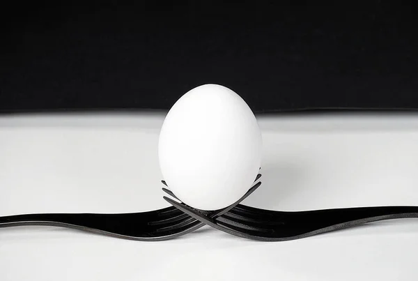 Крупним Планом Біле Яйце Балансує Парі Чорних Вилок Білому — стокове фото