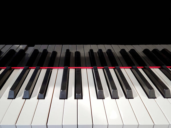 Close up of piano keyboard with shiny black reflection