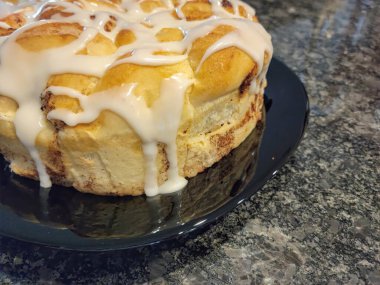 Ev yapımı tarçınlı ruloların üzerine beyaz krema damlat.