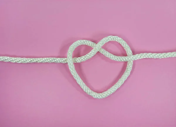 Close White Rope Heart Shape Know Pink Background — Zdjęcie stockowe
