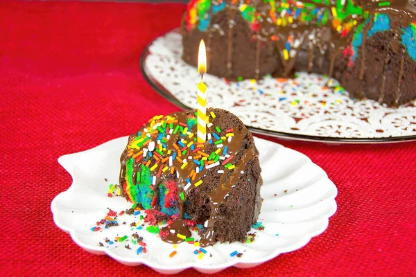 Verjaardagskaars Een Plakje Regenboog Chocolade Bundt Cake — Stockfoto