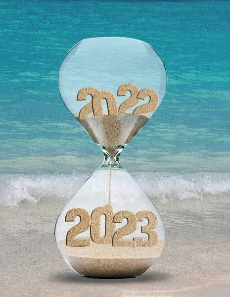 New Year 2023 sand timer on beach sand with a turquoise ocean watercolor background