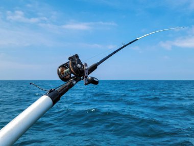 Fishing rod and reel on blue Lake Michigan water clipart