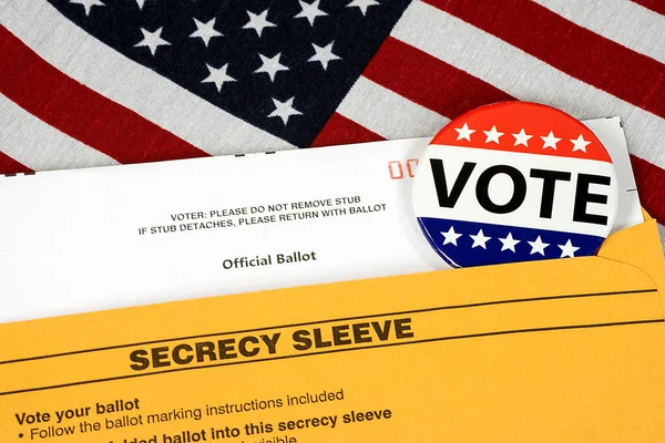 Vote button on mail-in ballot with envelope on an American flag