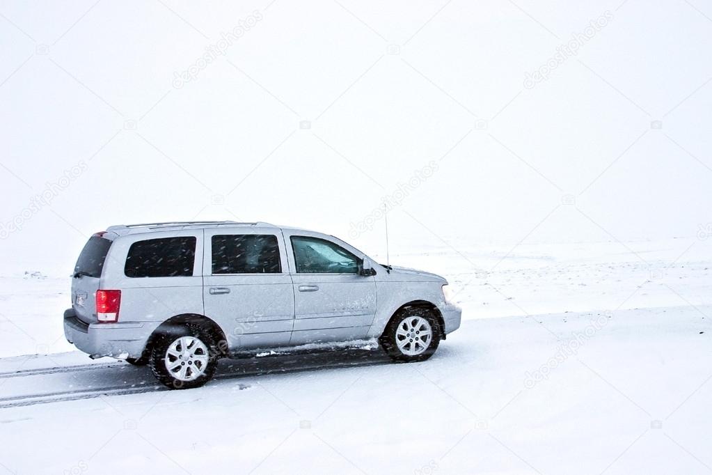 Offroad Car on the Snowy Road in Blizzard