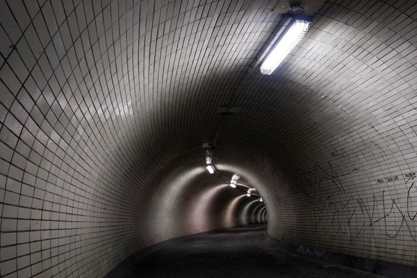 Perspektivní pohled přes tmavé floodlighted tunel — Stock fotografie