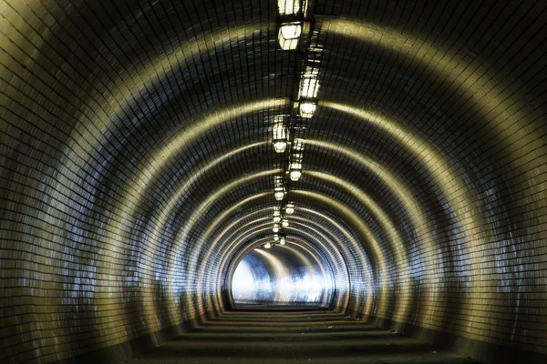 Vue à travers un tunnel sombre avec la lumière au bout — Photo
