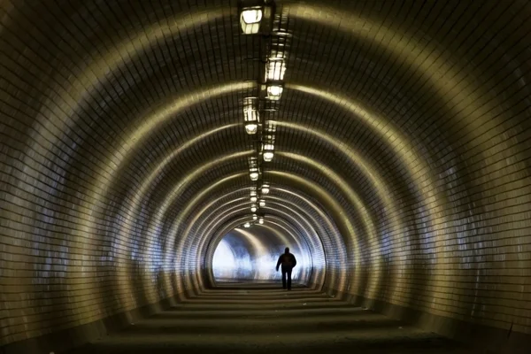 Perspektivischer Blick durch einen dunklen Tunnel mit menschlicher Silhouette — Stockfoto