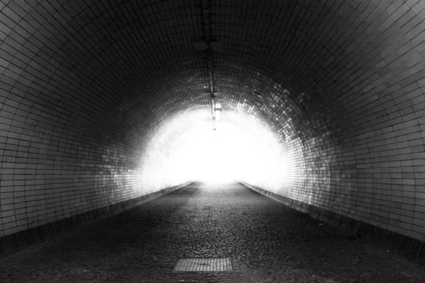 Se gennem en mørk tunnel med lyset i slutningen (sort og hvid ) Stock-foto
