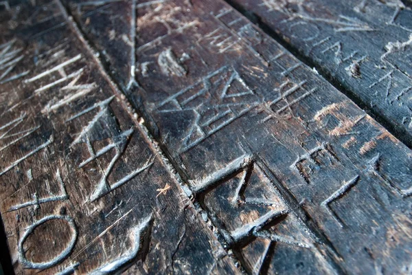 Textur einer alten geschnitzten Schrift auf Holztisch — Stockfoto