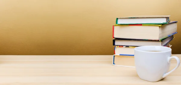 ahşap masa üzerinde yığın kitap